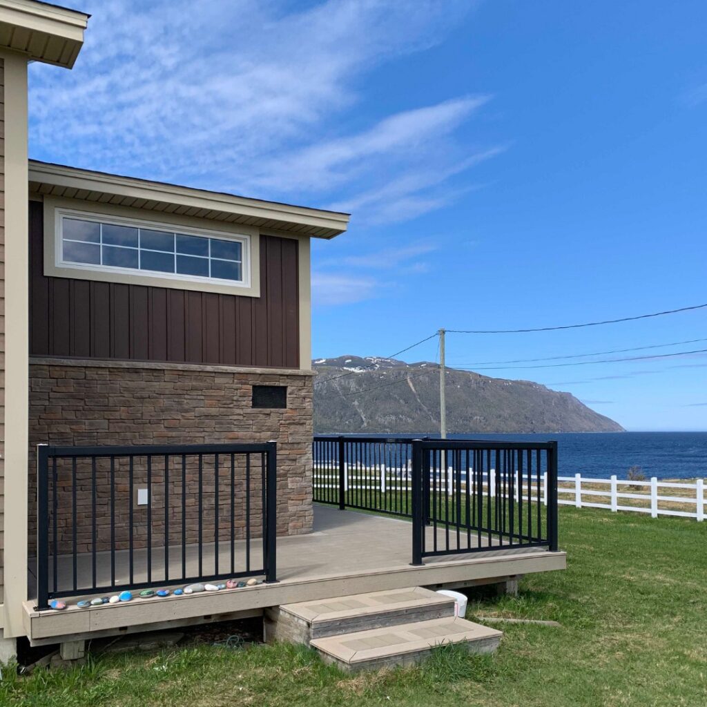 Waterfront home with Black Picket Railing by Century & Norris Point (Premier Siding)